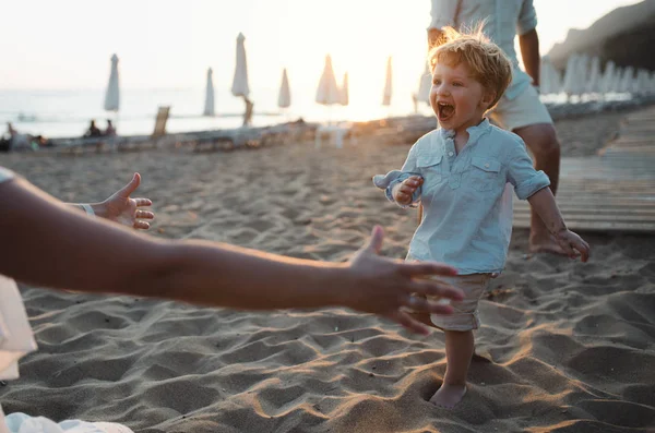 Młode rodziny z toddler chłopiec zabawy na plaży na letnie wakacje. — Zdjęcie stockowe