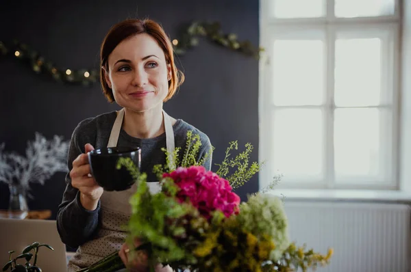 Creatieve jongedame in een bloemenwinkel. Een startup van bloemist bedrijf. — Stockfoto