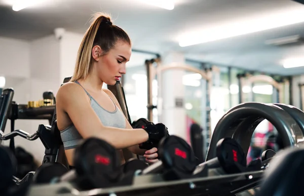 Giovane ragazza o donna con i manubri, facendo allenamento in palestra . — Foto Stock