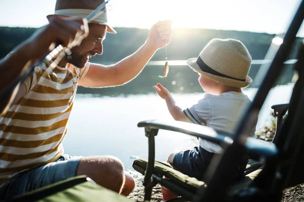 Starší otec se synem malé batole venku rybaření u jezera. — Stock fotografie
