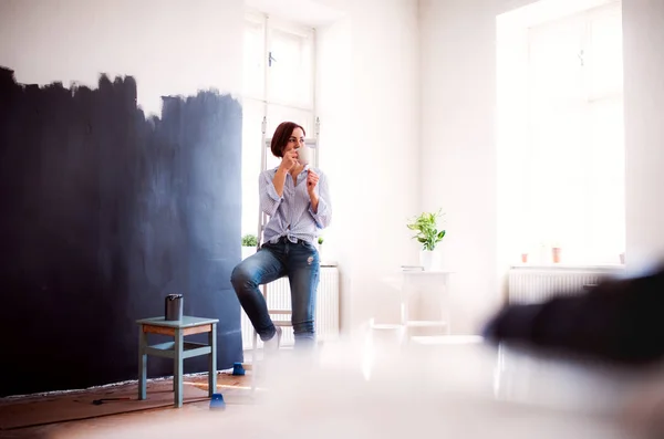 Een portret van de jonge vrouw schilderij muur zwart. Een opstarten van kleine ondernemingen. — Stockfoto