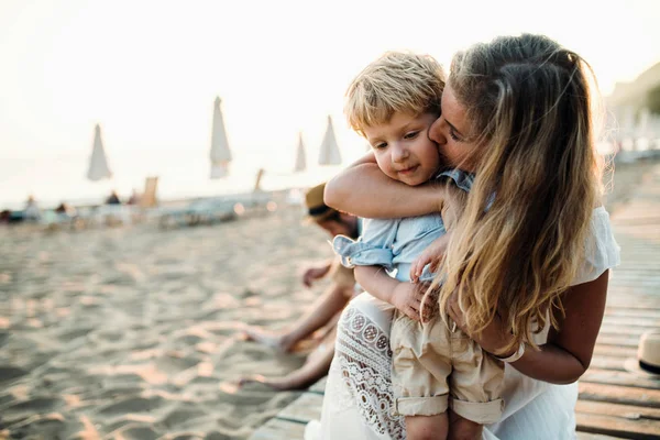 Giovane madre con un bambino ragazzo che si diverte sulla spiaggia in vacanza estiva . — Foto Stock