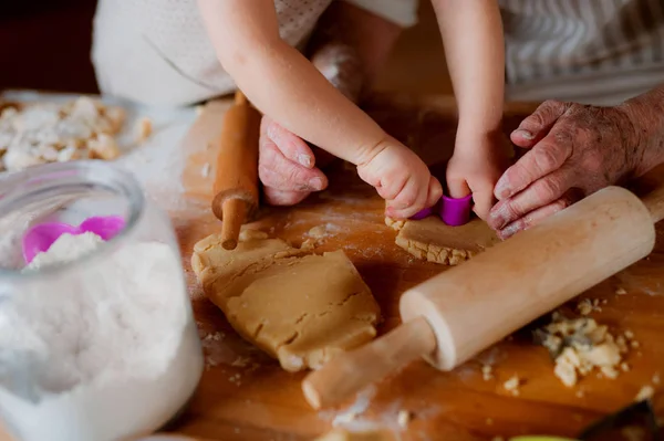 Buik van oma met kleine peuter jongen maken van taarten thuis. — Stockfoto