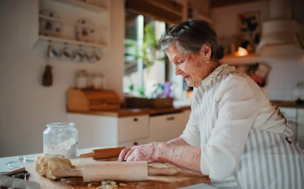 O femeie în vârstă face prăjituri într-o bucătărie acasă. Copiați spațiul . — Fotografie, imagine de stoc
