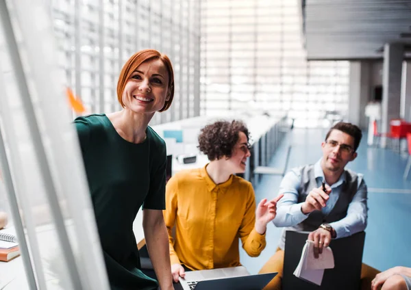 Group of young businesspeople in office, listening to a presentation. — Stock Photo, Image