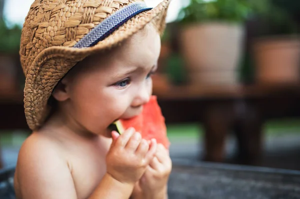 Liten flicka i badet utomhus i trädgården på sommaren, äter vattenmelon. — Stockfoto