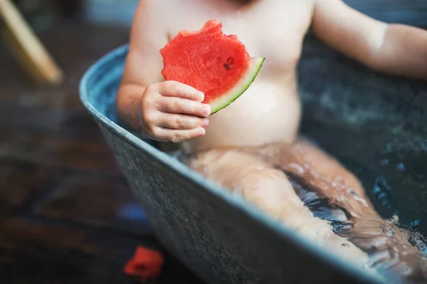 スイカを食べて、夏の庭で屋外風呂には小さな男の子の中央部. — ストック写真