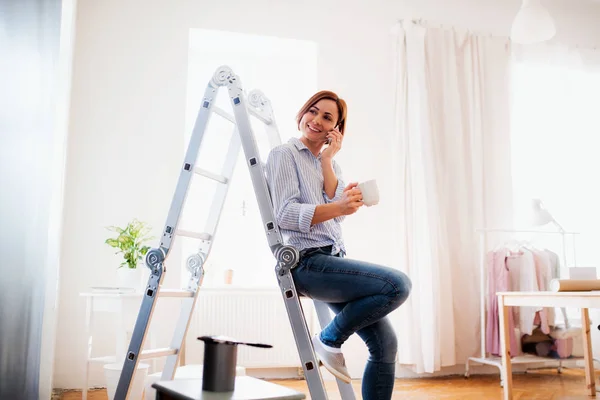 Een portret van de jonge vrouw schilderij muur zwart. Een opstarten van kleine ondernemingen. — Stockfoto