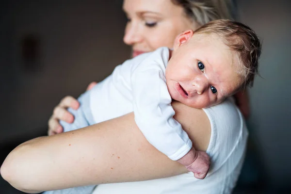 Seorang ibu muda yang cantik dengan bayi yang baru lahir di rumah . — Stok Foto