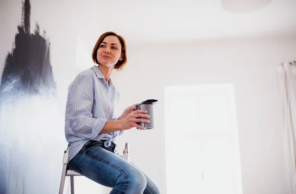 A portrait of young woman painting wall black. A startup of small business. — Stock Photo, Image