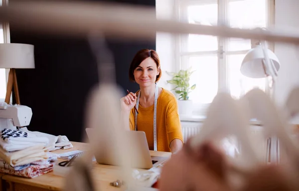 Jeune femme créative dans un studio, utilisant un ordinateur portable. Une start-up d'entreprise sur mesure . — Photo