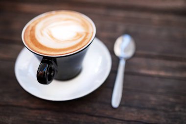 bir fincan kahve koyu ahşap bir masa üzerinde.