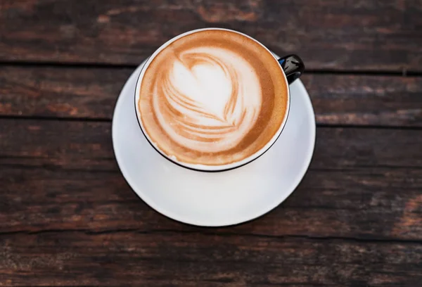 Eine Tasse Kaffee auf einem dunklen Holztisch. — Stockfoto