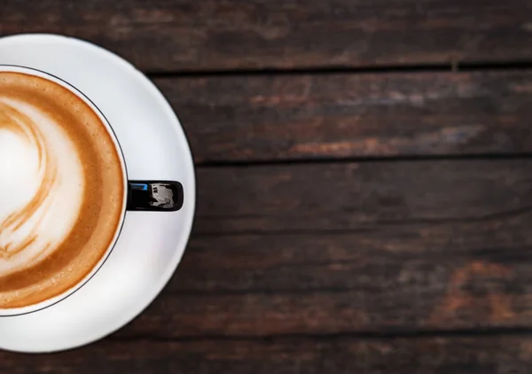 Eine Tasse Kaffee auf einem dunklen Holztisch. Kopierraum. — Stockfoto