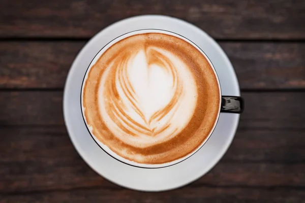 Eine Tasse Kaffee in Großaufnahme auf einem dunklen Holztisch. — Stockfoto
