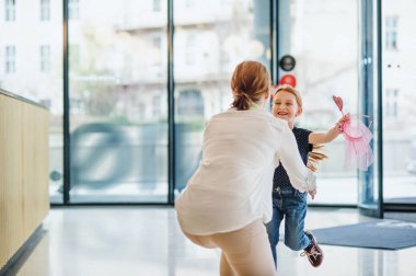 Ofis binasında küçük kızı ile tebrik işkadını bir arka görünümü.