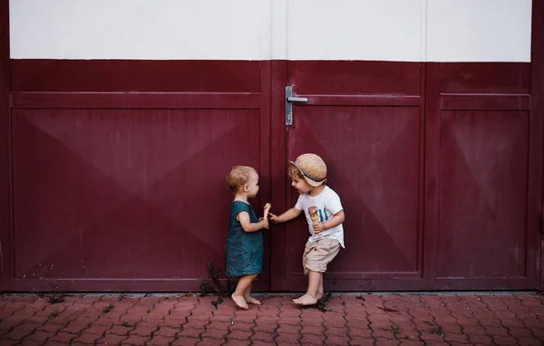 Pequeños dos niños pequeños al aire libre en verano, comiendo helado . — Foto de Stock