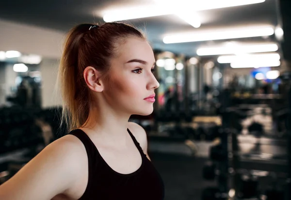 A portrait of young girl or woman standing in a gym. Copy space. — Stock Photo, Image