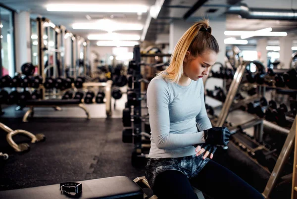 Genç kız ya da bir spor salonunda egzersiz yapıyor kadın dumbbells ile. — Stok fotoğraf