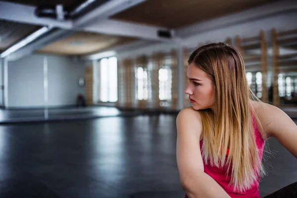 Genç kız üzgün ve sinirli ya da bir spor salonunda oturan kadın portresi. — Stok fotoğraf