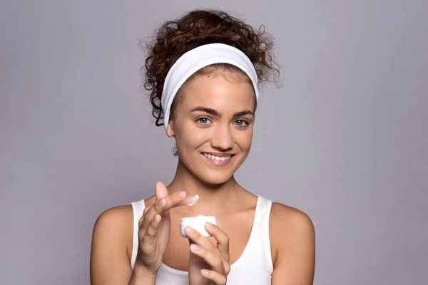 Een portret van een jonge vrouw met room in een studio, schoonheid en huidverzorging. — Stockfoto