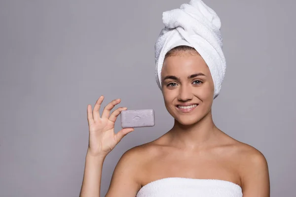 Un retrato de mujer joven con una barra de jabón en un estudio, belleza y cuidado de la piel . — Foto de Stock
