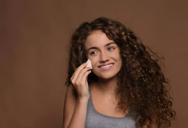 Ritratto di una giovane donna in uno studio, sfondo marrone. Bellezza e cura della pelle . — Foto Stock