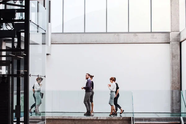 Grupo de jovens empresários no trabalho, caminhando no edifício . — Fotografia de Stock