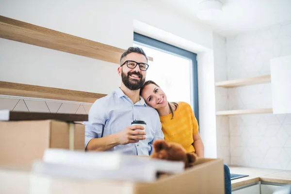 A young couple drinking coffee when moving in new home. — Stock Photo, Image