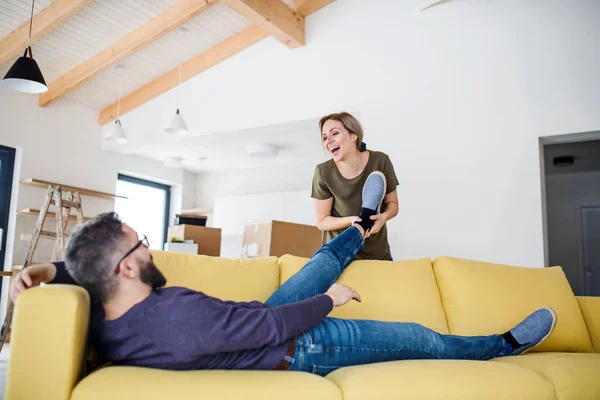 Um jovem casal se mudando para uma nova casa, se divertindo . — Fotografia de Stock