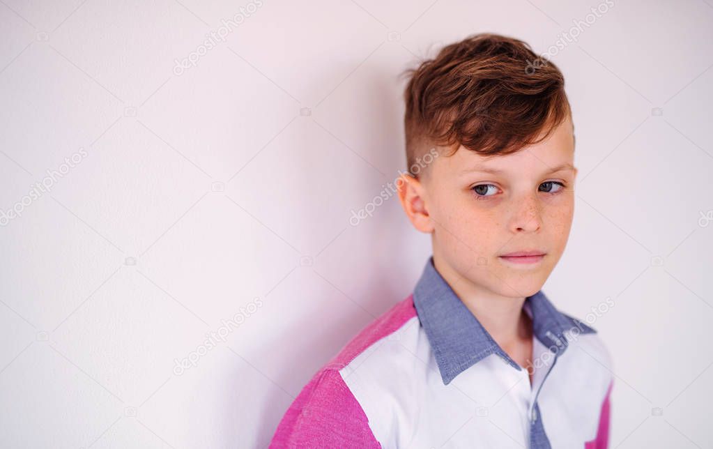 A portrait of small boy standing against white background. Copy space.