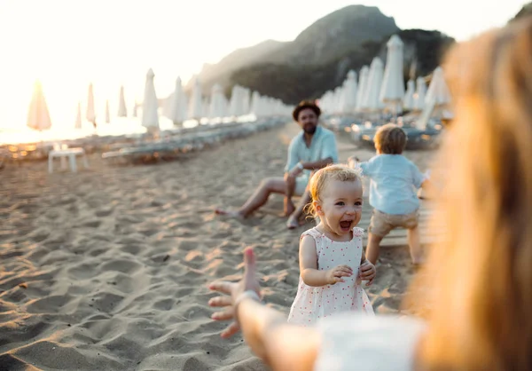 Junge Familie mit Kleinkindern im Sommerurlaub am Strand. — Stockfoto