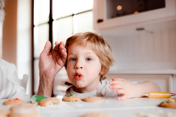 Una sezione centrale della nonna anziana con il piccolo bambino che fa torte a casa . — Foto Stock