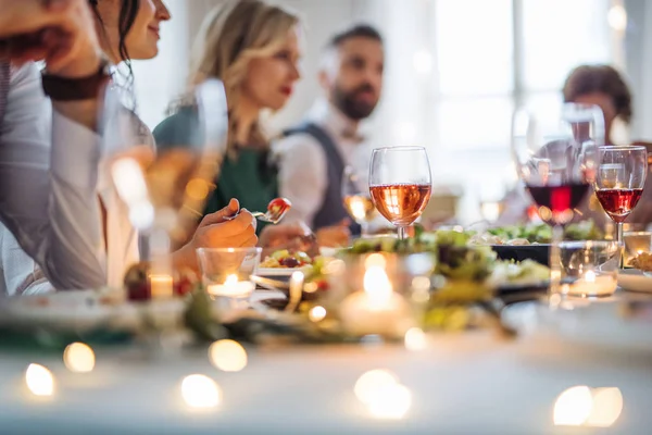 Una gran familia sentada en una mesa en una fiesta de cumpleaños cubierta, comiendo . — Foto de Stock