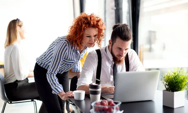 Een groep zakelijke mensen zitten in een kantoor, met behulp van laptop. — Stockfoto