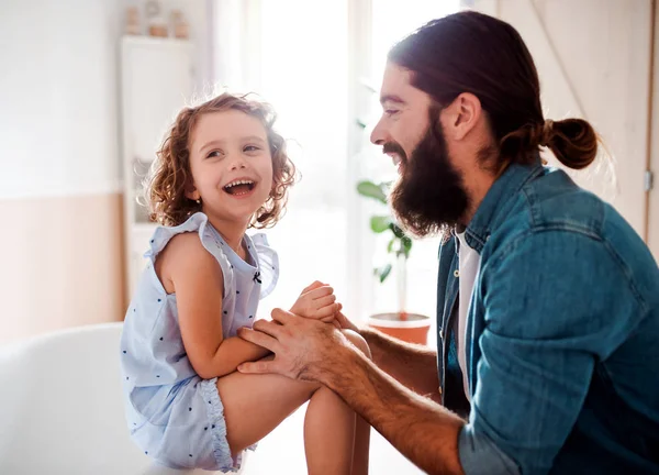 Uma menina pequena com o jovem pai em casa, a falar. Espaço de cópia . — Fotografia de Stock