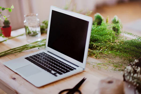 Een laptop op het Bureau in een bloemenwinkel. Een Startup van bloemist Business. — Stockfoto