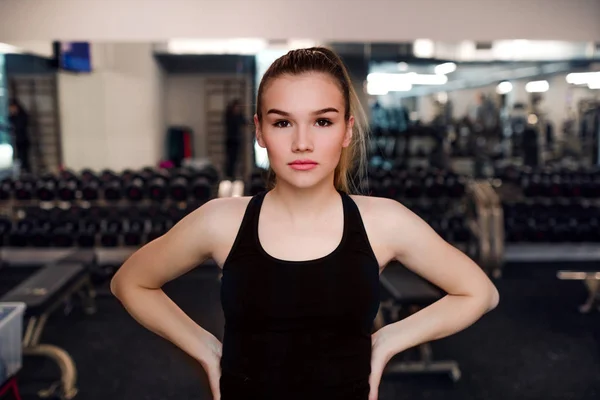 Ett porträtt av ung flicka eller kvinna stående i ett gym. — Stockfoto