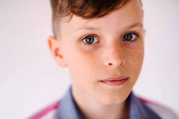 Close-up retrato de menino pequeno de pé contra fundo branco . — Fotografia de Stock