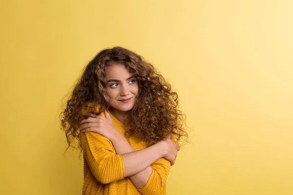 Portrait of a young woman in a studio on a yellow background. — Stock Photo, Image
