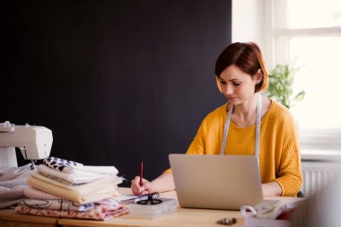 Genç yaratıcı kadın bir stüdyoda küçük terzilik iş başlangıç.