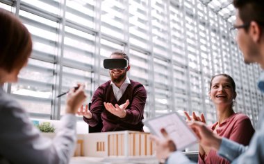 Ofiste çalışan genç Mimarlar grubu modeli Vr ve bir ev ile koruyucu gözlük.