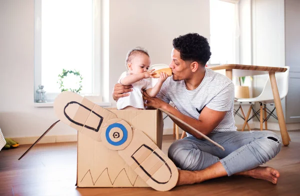 Pai e pequeno filho criança dentro de casa, brincando . — Fotografia de Stock