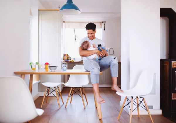 Ein Vater füttert einen kleinen Kleinkind-Sohn zu Hause. — Stockfoto