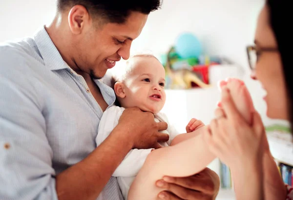 Giovane famiglia con piccolo figlio bambino al chiuso a casa, giocando . — Foto Stock