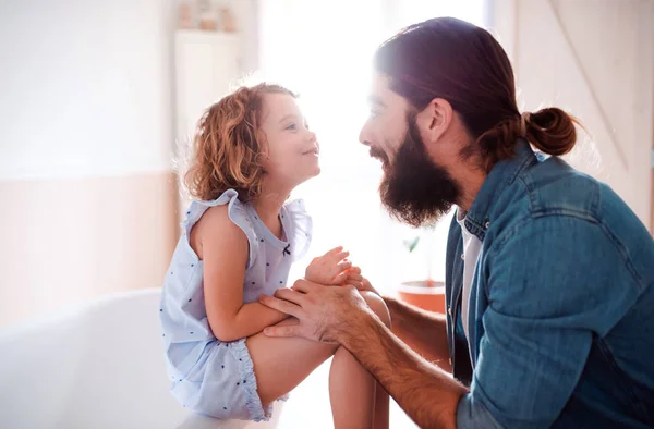 Uma menina pequena com o pai jovem em casa, falando . — Fotografia de Stock