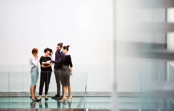 Gruppe junger Geschäftsleute steht in der Nähe der Treppe und redet. — Stockfoto