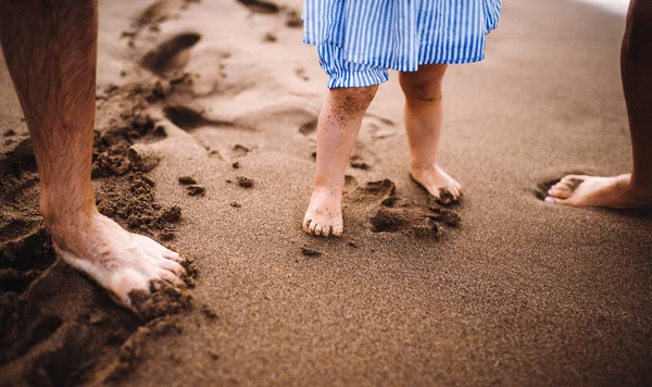 Сечовипускання батьків з дочкою малюка, що стукає на пляж на літні канікули . — стокове фото