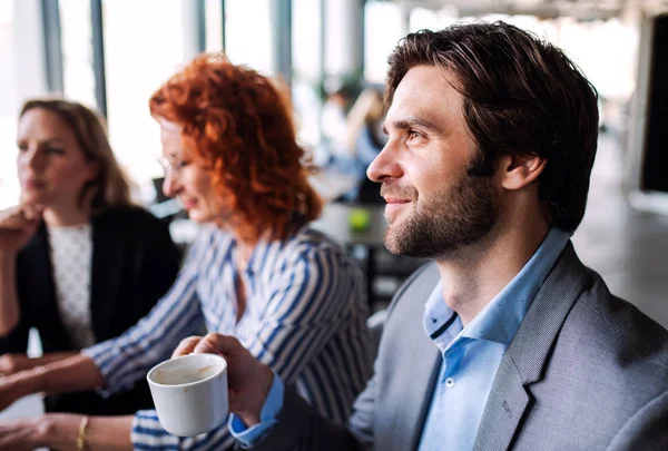 Eine Gruppe junger Geschäftsleute sitzt in einem Büro und arbeitet. — Stockfoto