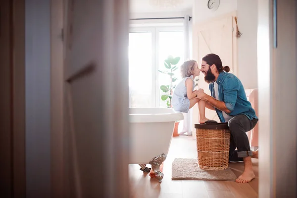 Uma menina pequena com o pai jovem no banheiro em casa, se divertindo . — Fotografia de Stock